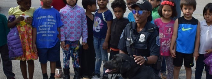 Police officer posing with students during career day with police dog